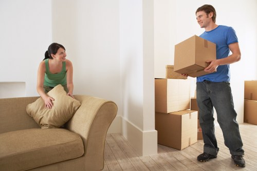 Removal workers carrying furniture through a shared hallway in Richmond